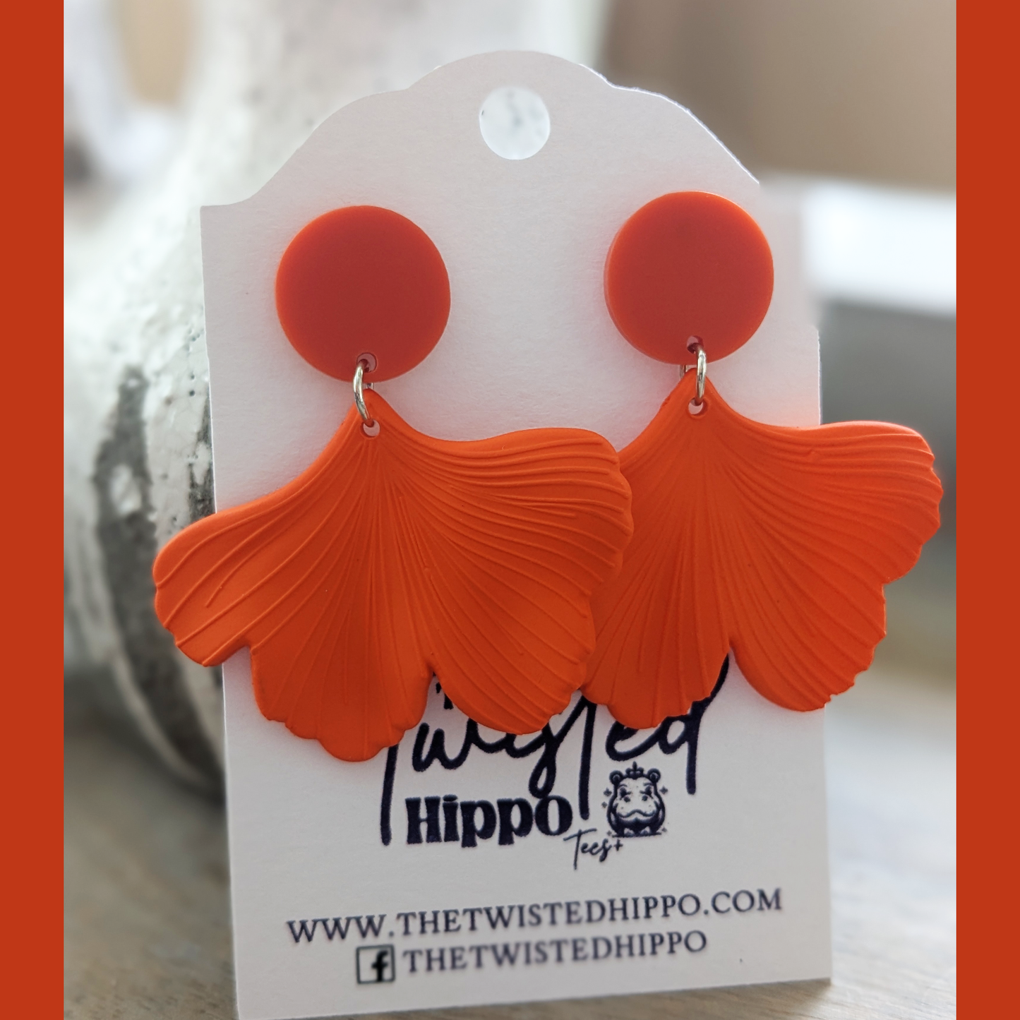 "Lightweight acrylic fan earrings in bold orange for themed looks"