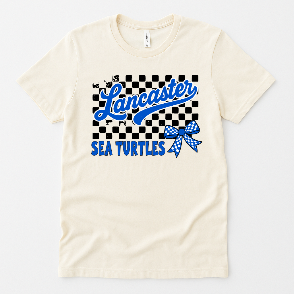 Lancaster Sea Turtles shirt with checkered background, blue bow, and varsity script – natural color flat lay

