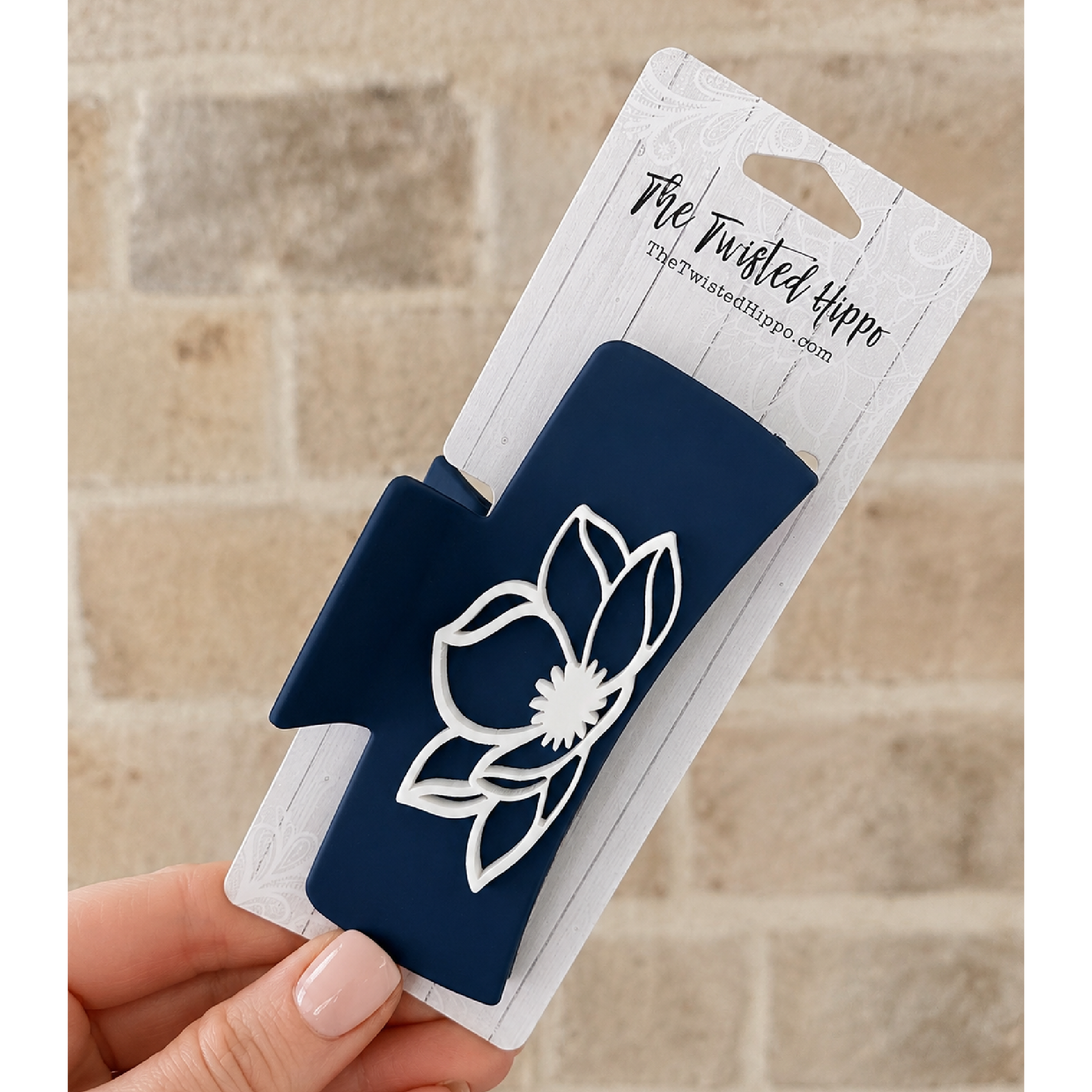 Navy acrylic hair claw clip featuring a white magnolia flower design on both sides.