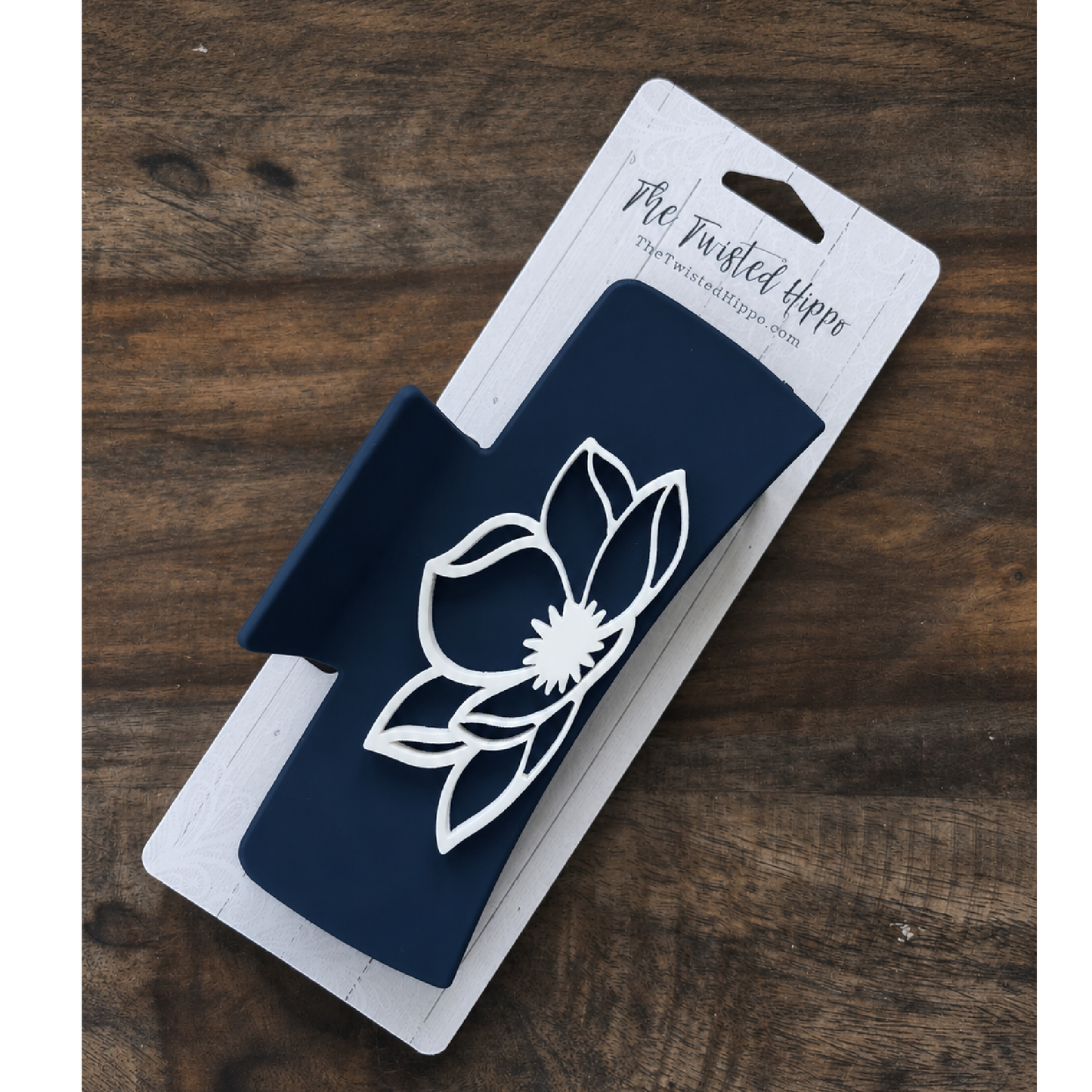 Navy acrylic hair claw clip featuring a white magnolia flower design on both sides.