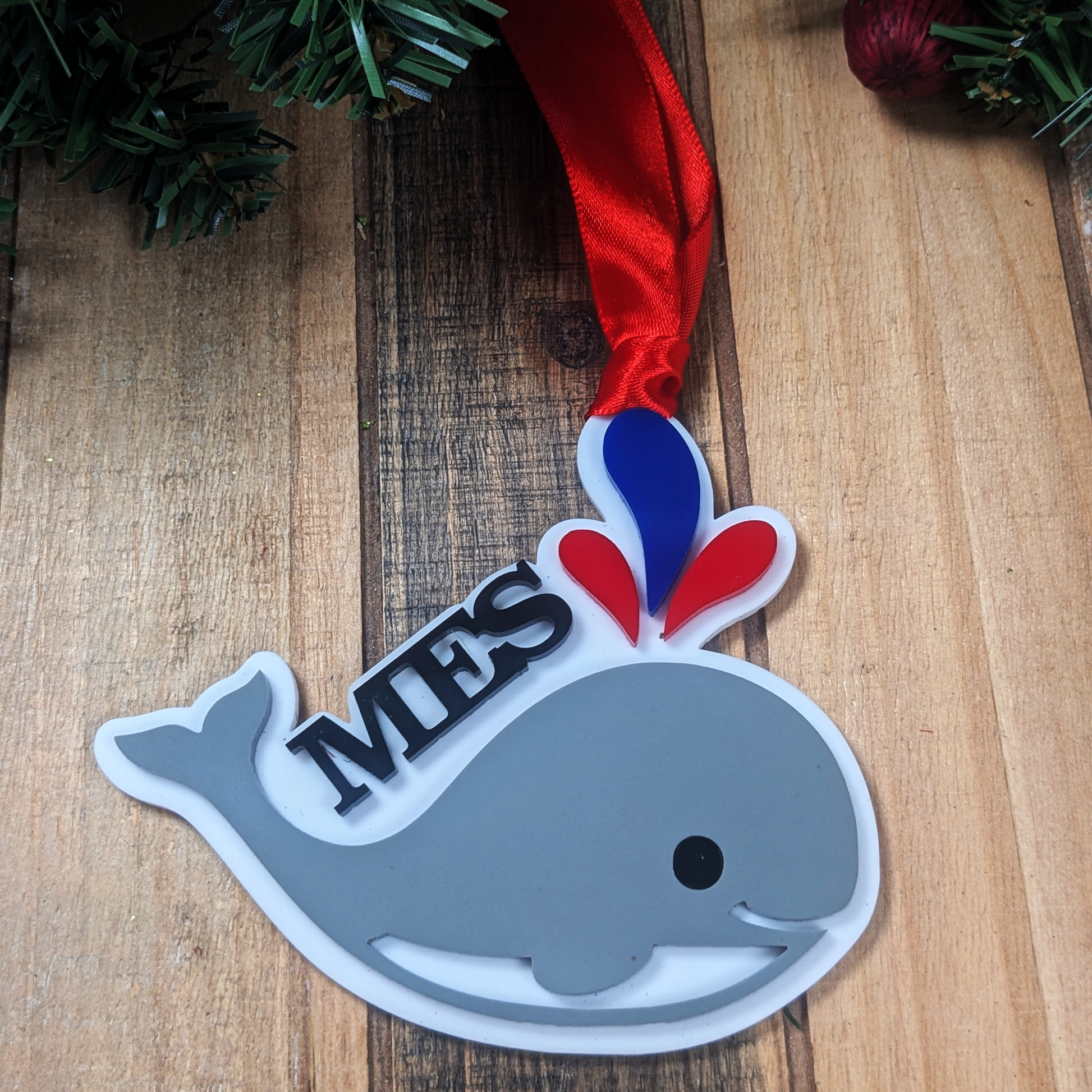 Mandeville Elementary Whales acrylic Christmas ornament with red ribbon